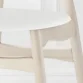 close view of cane dining chair showing faux leather seat