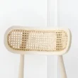 close view of cane backrest of dining chair.