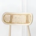 backrest detailed breathable rattan cane weave in a rounded frame, Nordic dining chair design with natural wood finish.