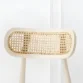close view of cane backrest of dining chair.