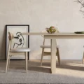 Scandinavian dining room scene featuring light wood dining table with six matching cane-back chairs.