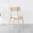 rear view of Scandinavian wooden dining chair with white seat and curved rattan cane backrest for modern dining rooms.