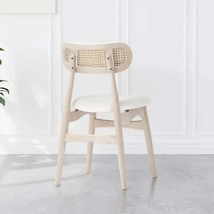 rear view of Scandinavian wooden dining chair with white seat and curved rattan cane backrest for modern dining rooms.