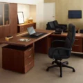 A spacious executive office with a wooden desk and multiple drawers.