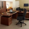 A spacious executive office with a wooden desk and multiple drawers.