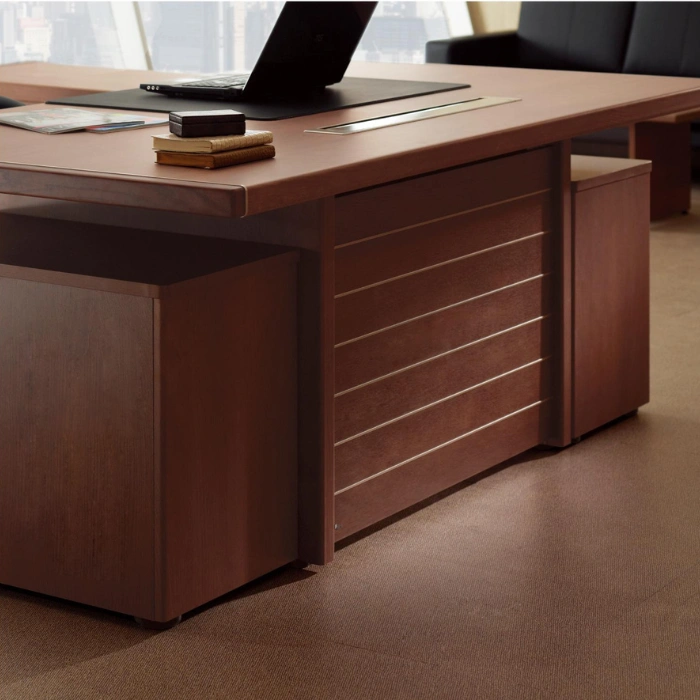 A close-up of a brown wooden executive desk with modern metallic accents.