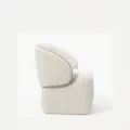 side profile view of white boucle armchair