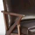 close view of leather chair showing wooden armrest.