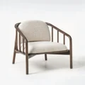 Angled view of wooden armchair with beige cushions