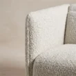 Close-up of the textured off-white upholstery and padded arm edge