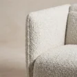 Close-up of the textured off-white upholstery and padded arm edge