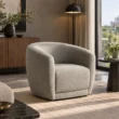 CreamCove curved armchair in warm ivory upholstery styled in a modern living room