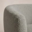 Close-up of the textured grey upholstery and curved arm seam