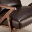 Close-up of Fiora armrest, wood frame and dark brown upholstered seat