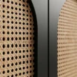 Close-up of natural cane weave set inside the black arched door frame
