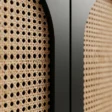 Close-up of natural cane weave set inside the black arched door frame