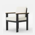 Angled view of cushioned patio dining chair with teak armrests, weather resistant outdoor furniture