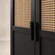 Close-up of slim black handles beside natural cane door panels