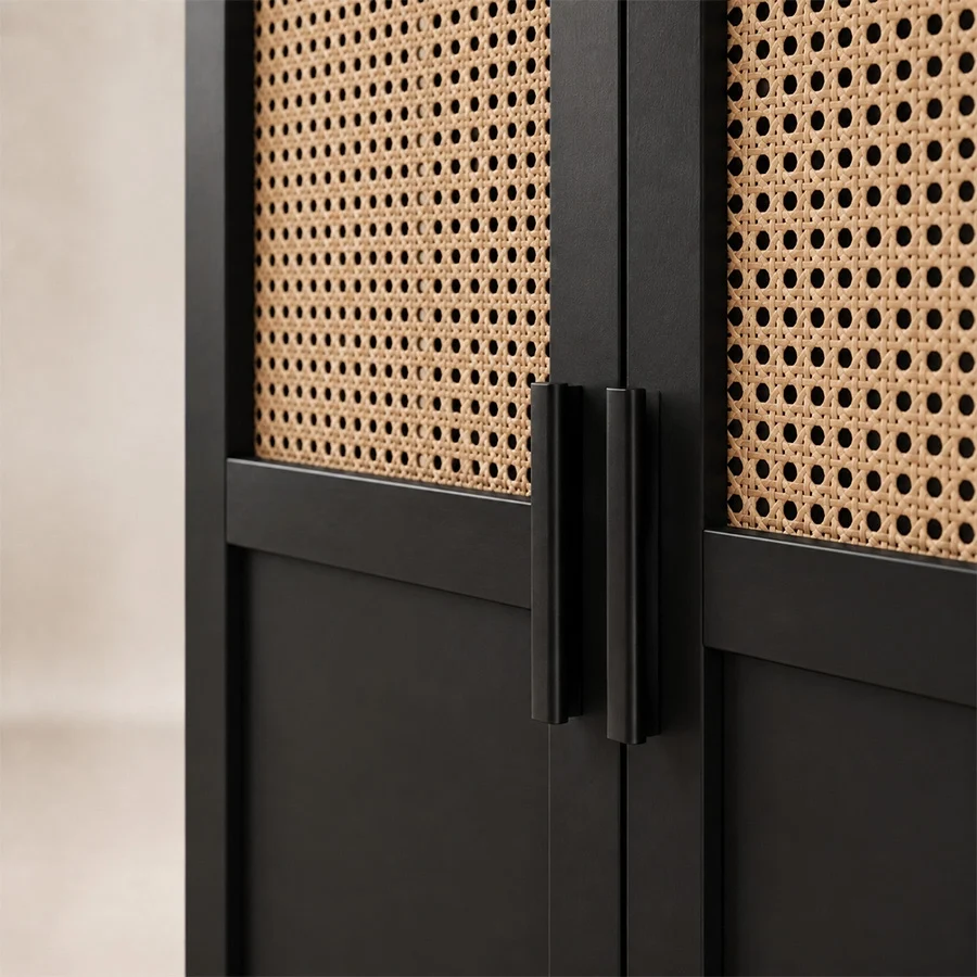 Close-up of slim black handles beside natural cane door panels