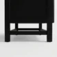 Close-up of the short angled black legs and sturdy base of the Arcane modern rattan wardrobe.