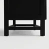 Close-up of the short angled black legs and sturdy base of the Arcane modern rattan wardrobe.
