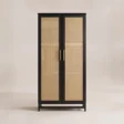 Front view of black two-door wardrobe with natural cane panels