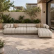 Fjord modular outdoor sofa with ivory upholstery in a landscaped patio setting