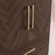 Close-up of brass-tone handles on the walnut chevron wardrobe doors