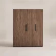 Front view of fluted wooden wardrobe with walnut-toned doors and black handles