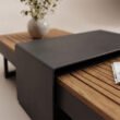 Close-up of dark metal centre panel and teak table surface