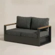 Angled view of Reefline 2-seater sofa with teak arm accents