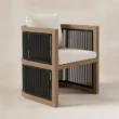 Three-quarter view of curved Wharf dining chair with dark rope weaving.