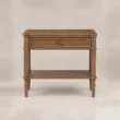Aldren wooden bedside table with single drawer, open shelf, warm brown finish, and turned legs.