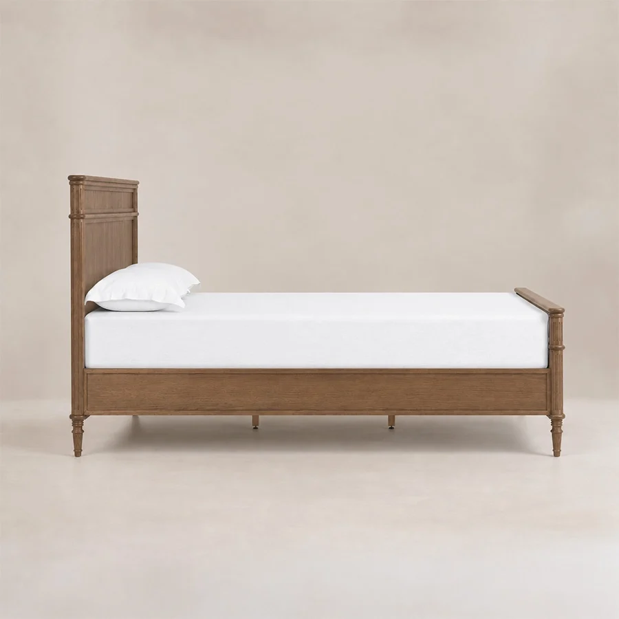 Aldren Platform Bed side view Side view of Aldren wooden bed with paneled frame, turned legs, and warm brown finish.