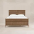 Aldren Wooden Bed in warm brown wood finish with panel headboard and matching footboard, front view.
