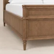 Close-up of Modern Aldren wooden bed showing framed wood panels, carved detailing, and turned leg.