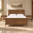 Aldren Wooden Bed in warm brown finish with matching bedside tables in a styled bedroom.