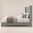 Side view of Bellmere Wingback Bed in grey upholstery with tufted headboard and nailhead trim.