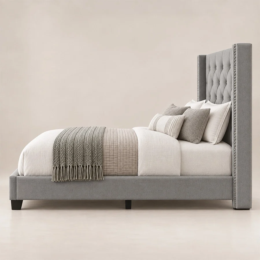 Side view of Bellmere Wingback Bed in grey upholstery with tufted headboard and nailhead trim.