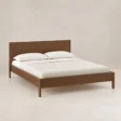 Angled view of Kelden Linea Bed in Walnut Brown finish with clean panel headboard and slim wooden legs.