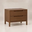 Angled view of Kelden Linea matching two-drawer bedside table in Walnut Brown finish with recessed handles and slim wooden legs.
