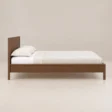 Side view of Kelden Linea Bed in Walnut Brown finish with clean panel headboard and slim wooden frame.