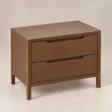 Angled view of Kelden Linea two-drawer bedside table in Walnut Brown finish with recessed handles and slim wooden legs.