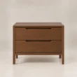 Front view of Kelden Linea matching two-drawer bedside table in Walnut Brown finish with recessed handles and slim wooden legs.