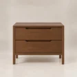 Front view of Kelden Linea matching two-drawer bedside table in Walnut Brown finish with recessed handles and slim wooden legs.