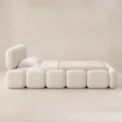 Angled view of Mirelle Upholstered Bed in ivory boucle fabric.
