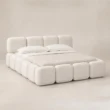 Angled view of Mirelle Upholstered Bed in ivory boucle fabric.