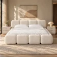 Mirelle Bubble Bed set in off-white boucle upholstery with matching bedside tables in a modern bedroom setting.