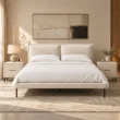 Nolven Softline Upholstered Bed Set in warm ivory fabric with matching bedside tables in a modern bedroom.