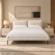 Nolven Softline Upholstered Bed Set in warm ivory fabric with matching bedside tables in a modern bedroom.